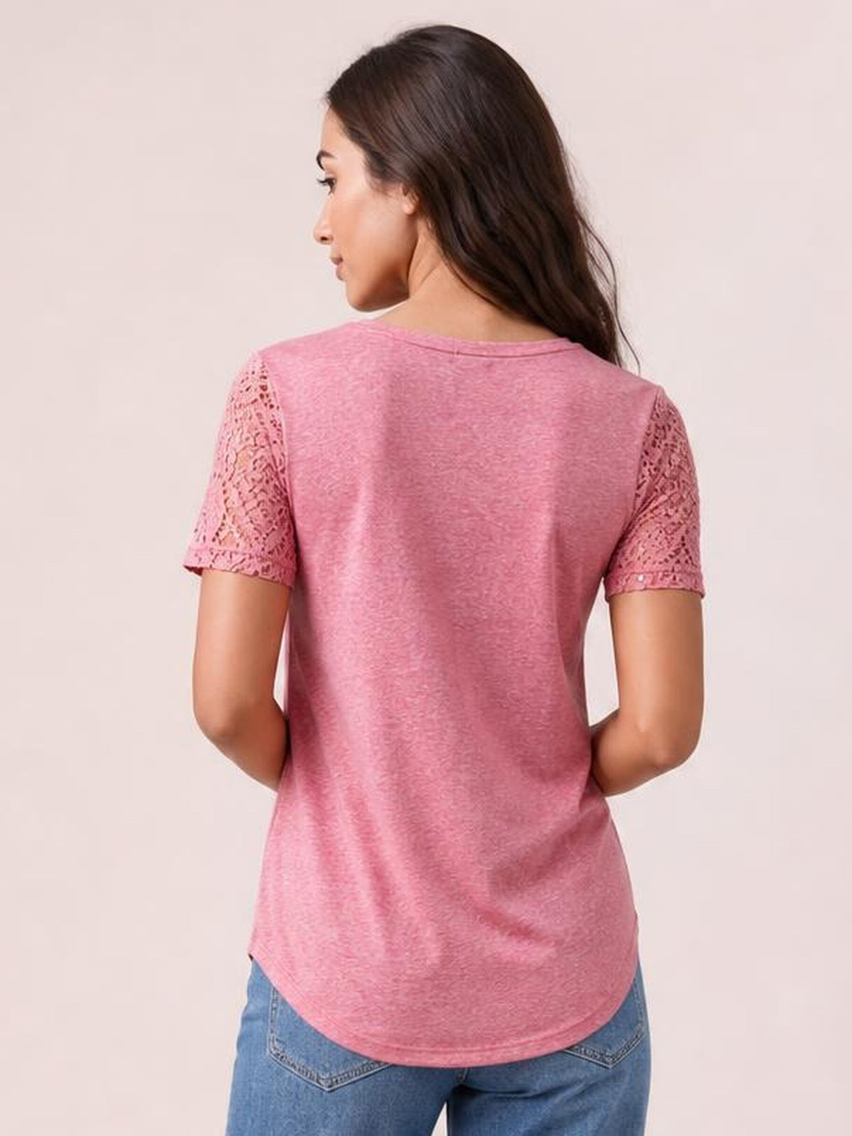 A model poses from the back in a pink round-neck short-sleeve T-shirt with cutout openwork sleeves, a relaxed silhouette, and curved hem.