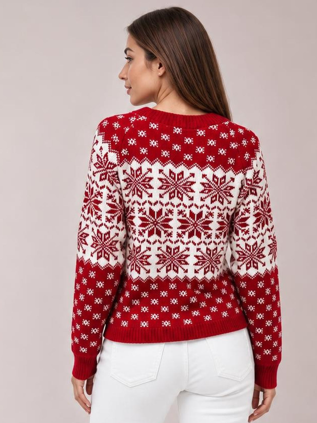 Model turned to show the back of a red and white snowflake pattern long sleeve sweater with a ribbed crew neckline, cuffs, and hem.