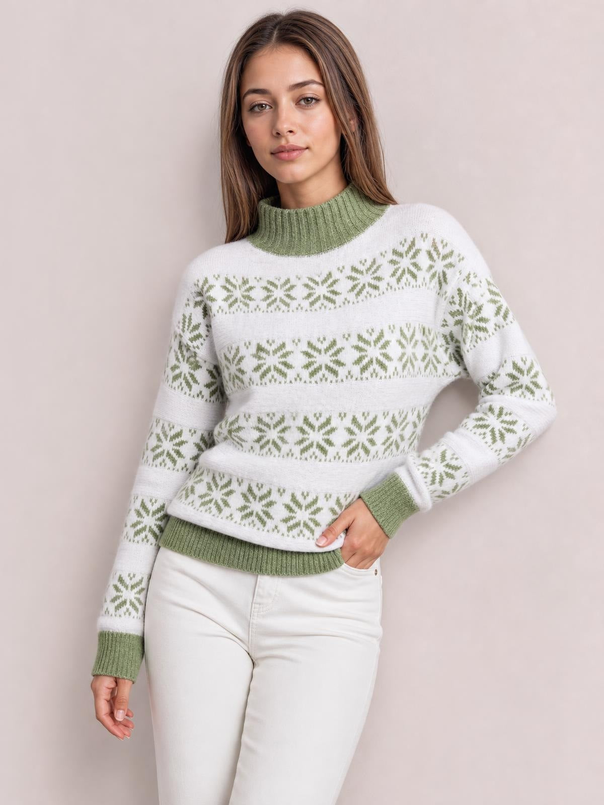 A woman poses in a white snowflake pattern sweater with a green ribbed mock neck, cuffs, hem, and relaxed long-sleeve silhouette.