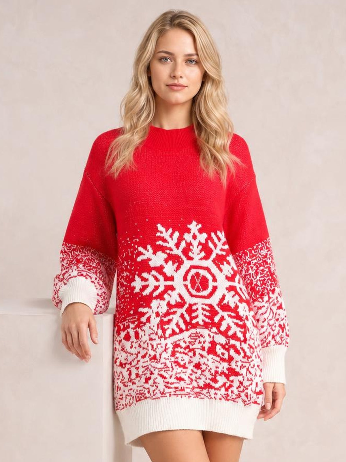 Model stands wearing a red ribbed sweater dress with a relaxed silhouette, long sleeves, white snowflake pattern, and contrasting ribbed cuffs and hem.