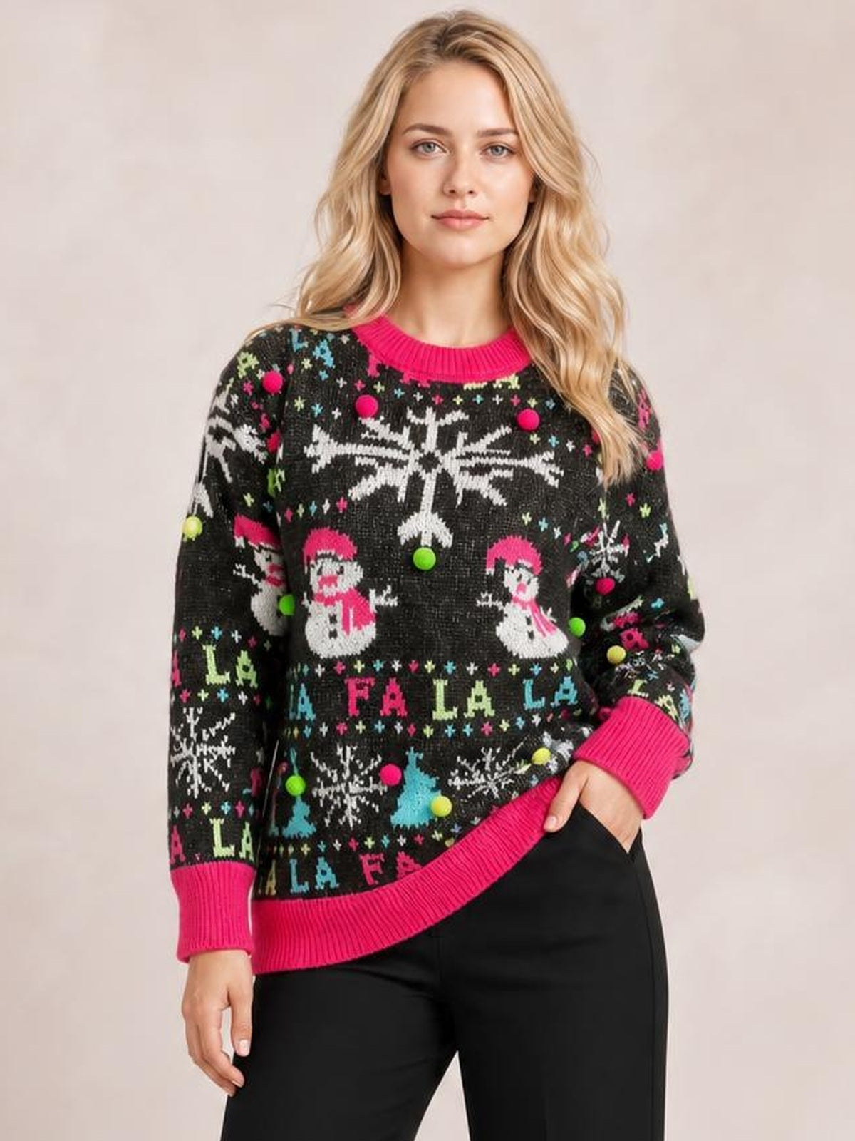 Model wearing a relaxed black Snowman contrast trim round neck sweater with colorful festive motifs, long sleeves, and bright pink ribbed neckline, cuffs, and hem.