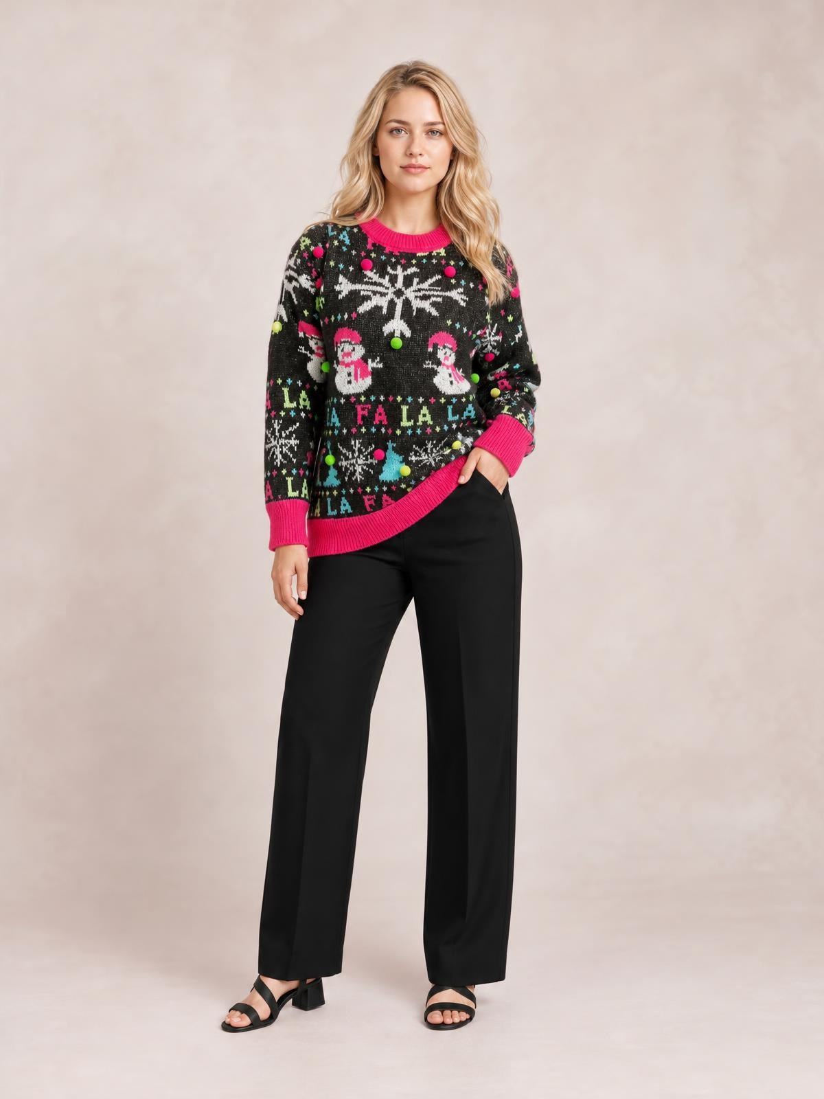 Model poses in a black Snowman contrast trim round neck sweater with colorful winter motifs, pink ribbed neckline, cuffs and hem, and a relaxed silhouette.