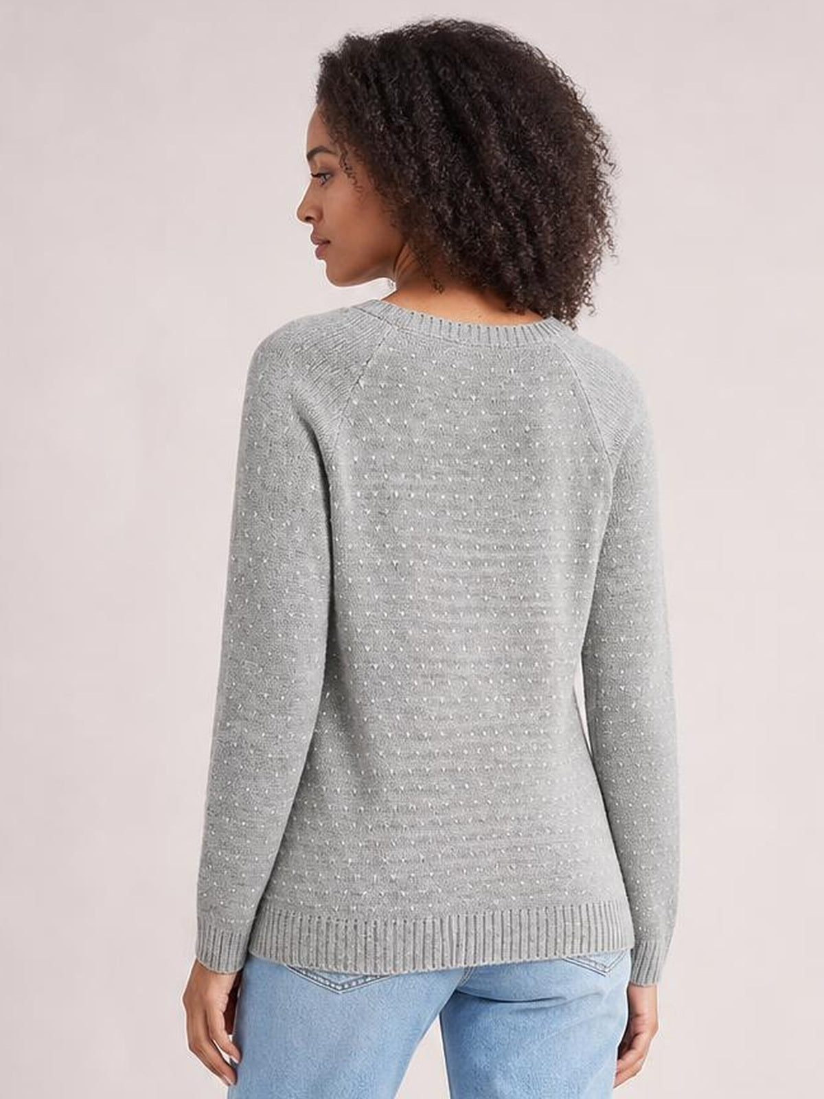 A model shown from the back wears a gray raglan sleeve sweater with a crew neckline, long sleeves, textured knit, and ribbed hem and cuffs.