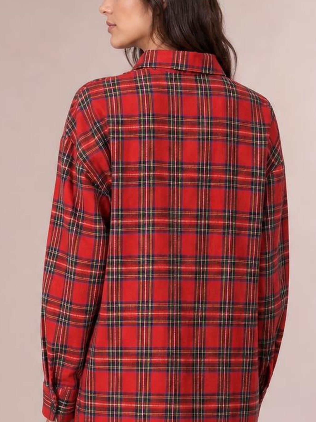 Back view of a model wearing a red checker plaid oversized shirt dress with a pointed collar, long sleeves, relaxed silhouette, and buttoned cuffs.