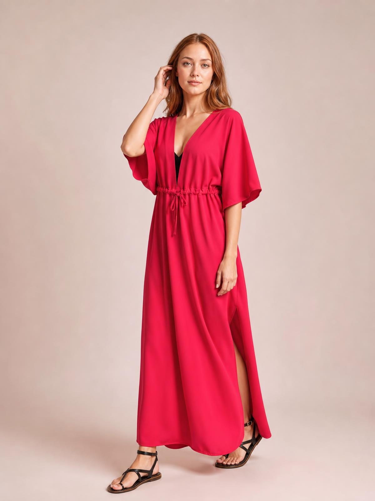 Model wearing a solid fuchsia flutter sleeve cover-up with a tied waist, V-neckline, flowing maxi silhouette, and side slit.
