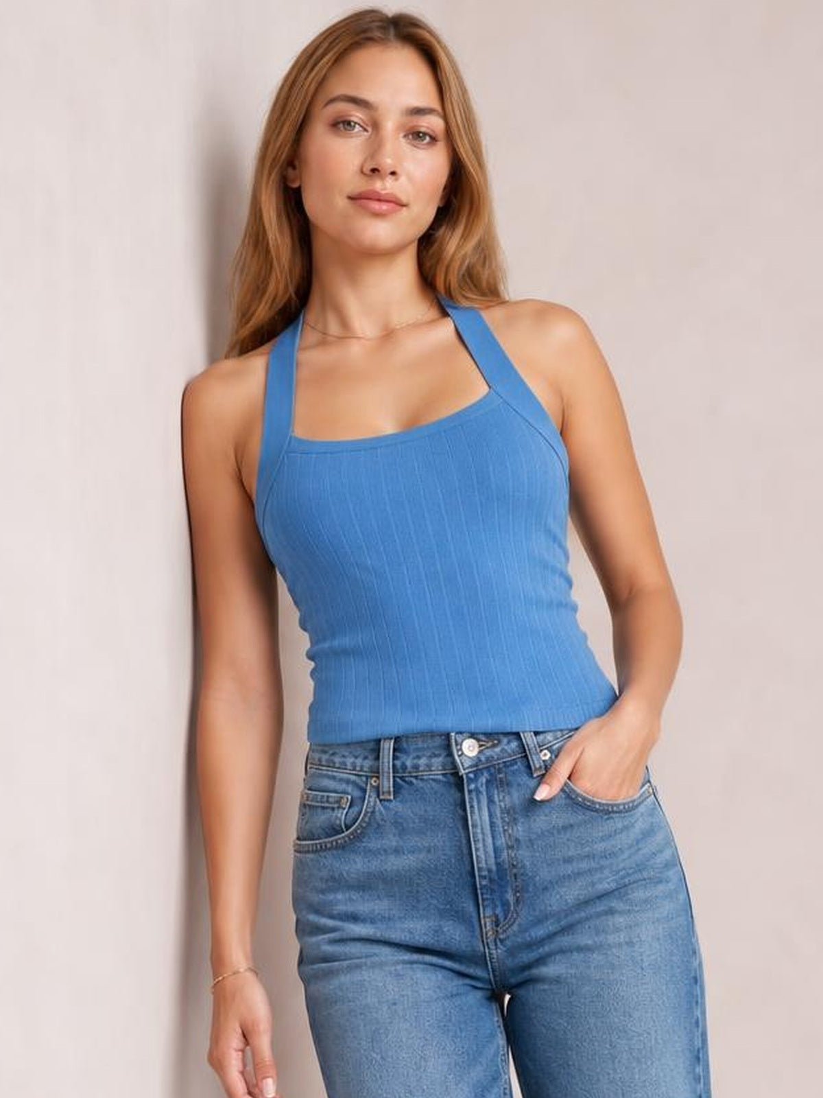 A model wears a solid blue halter neck knit cami with wide straps, square neckline, vertical ribbed texture, fitted silhouette, and a slightly stretchy construction.