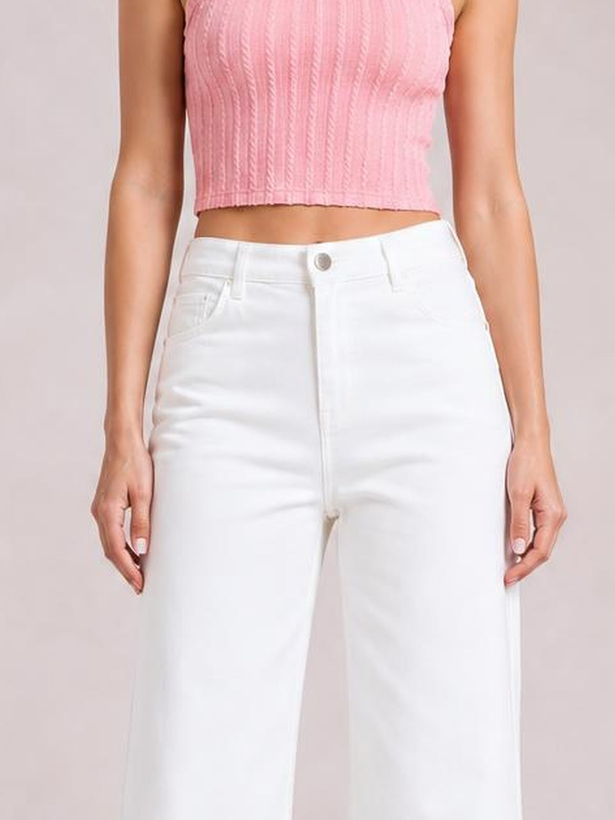 A model stands with hands at her sides, wearing solid white loose casual jeans with a straight-leg silhouette, belt loops, button closure, and front pockets.