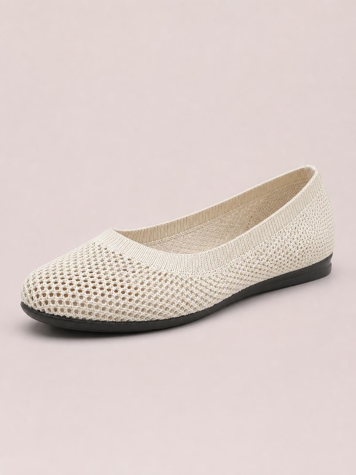 Cream-colored mesh flat slip-on with a rounded toe, low-profile black rubber sole, and flexible woven upper in a solid color.