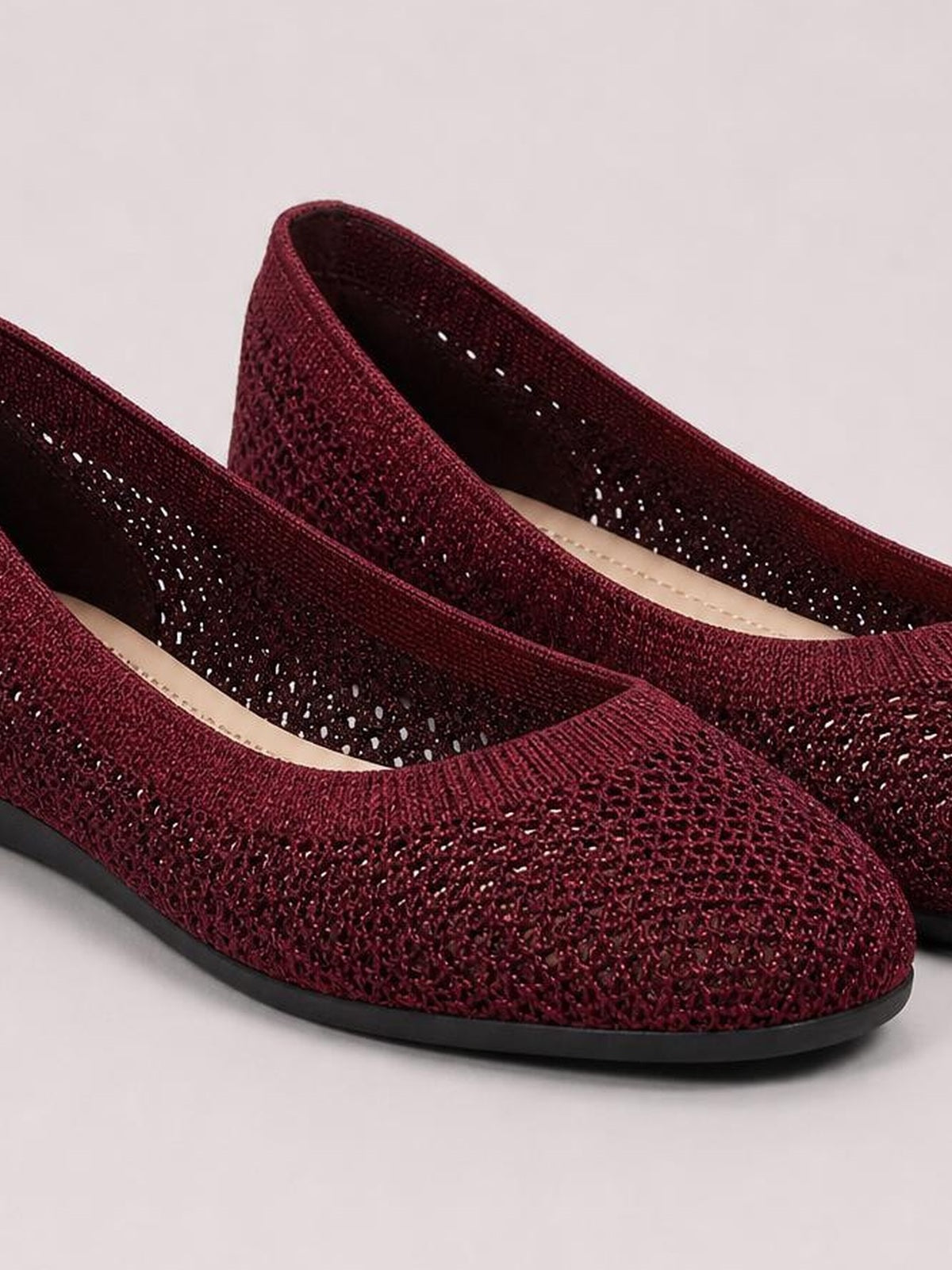 Burgundy mesh flat slip-ons feature rounded toes, textured woven uppers, dark interiors, and low black rubber soles for a streamlined silhouette.