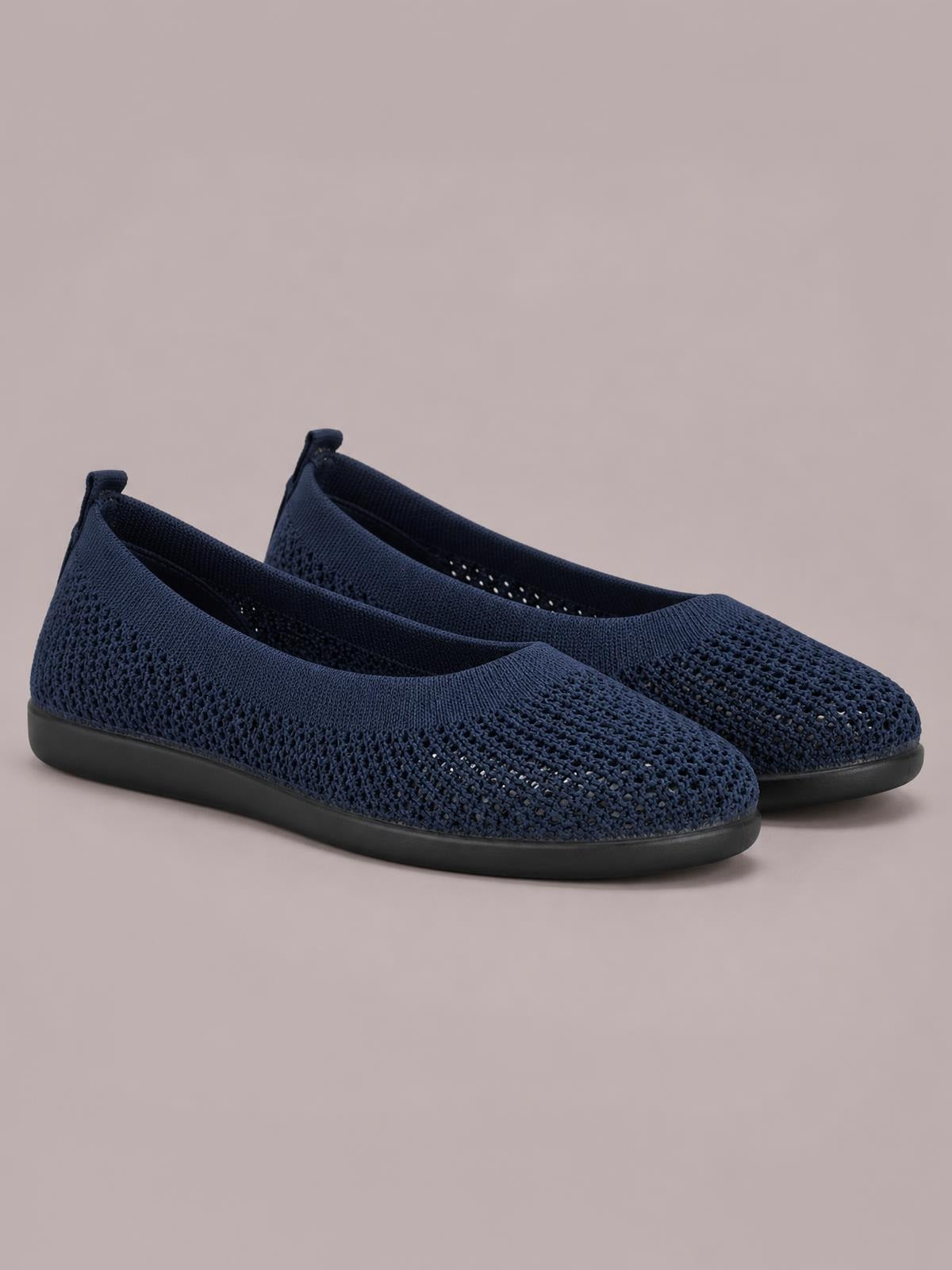 Solid navy mesh flat slip-on shoes with rounded toes, elasticized openings, textured woven construction, and low black rubber soles.