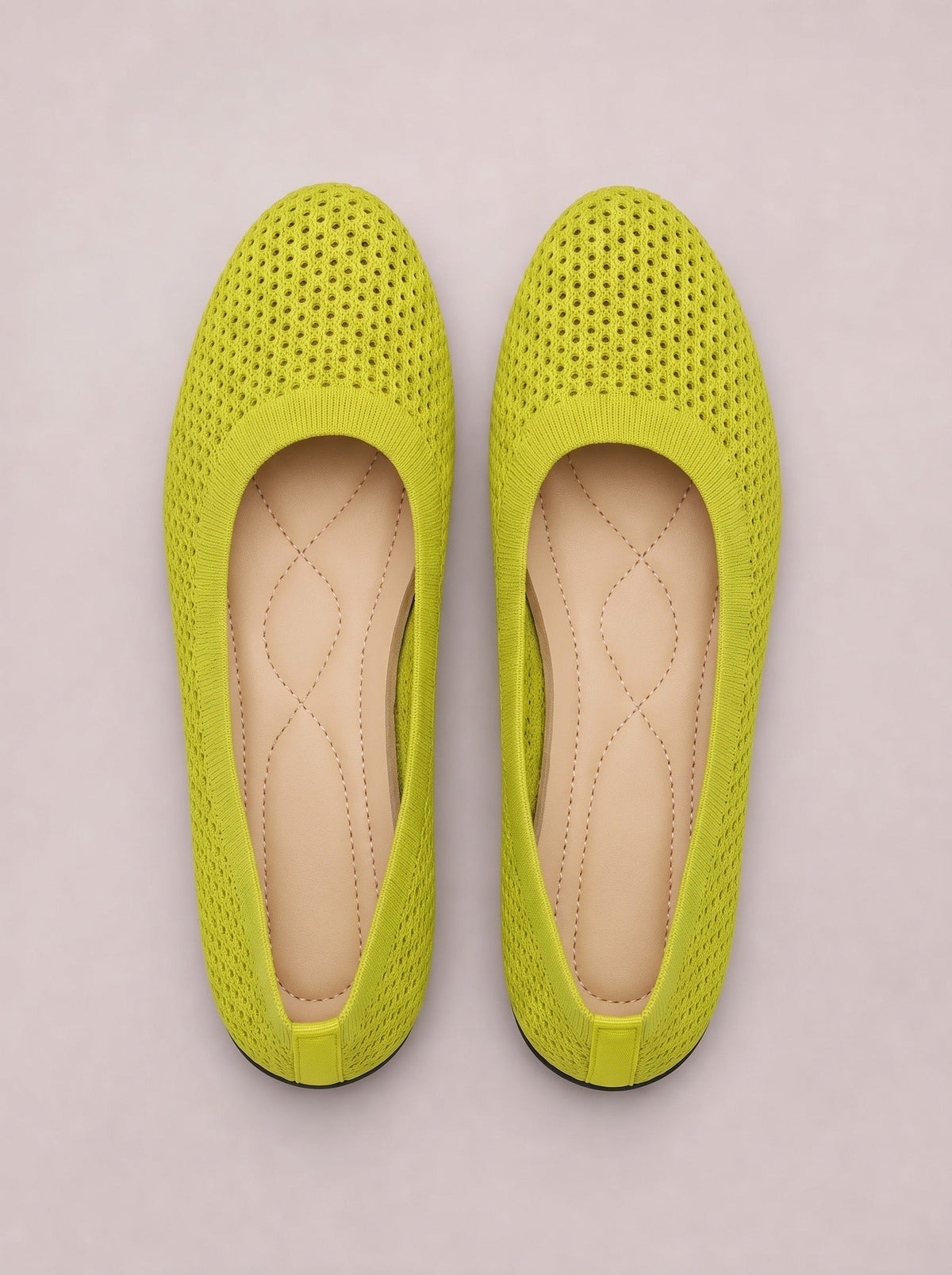 Neon yellow mesh flat slip-on shoes with perforated uppers, rounded toes, elastic trim, stitched insoles, and low rubber soles.