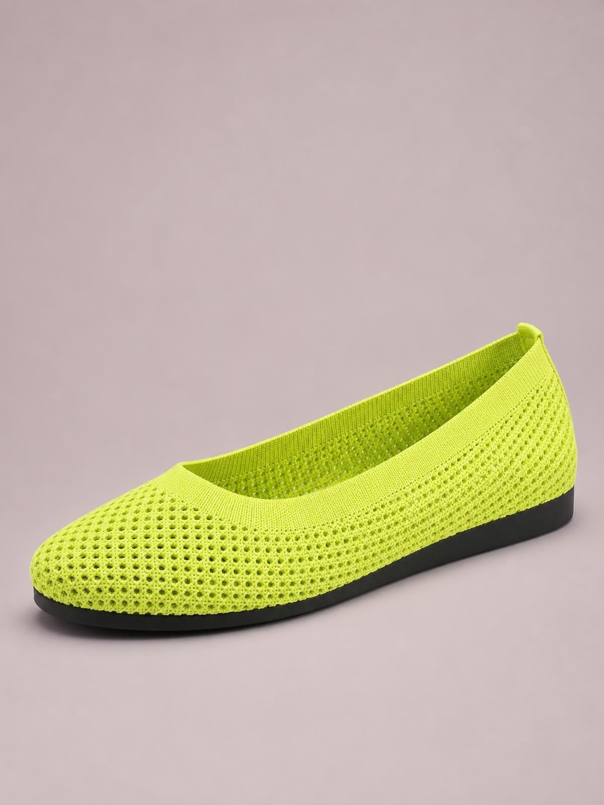 Bright lime green mesh flat slip-on with a rounded toe, perforated knit construction, and a low-profile black rubber sole.