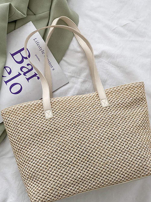 A medium beige woven tote bag with a clean structured rectangular silhouette, textured construction, and long shoulder straps for hand or over-the-shoulder carrying.