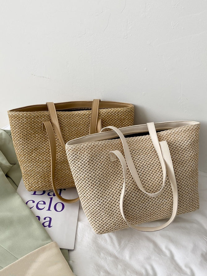 Two medium solid-color woven tote bags in tan and cream feature structured rectangular silhouettes, open tops, textured construction, and long shoulder straps.