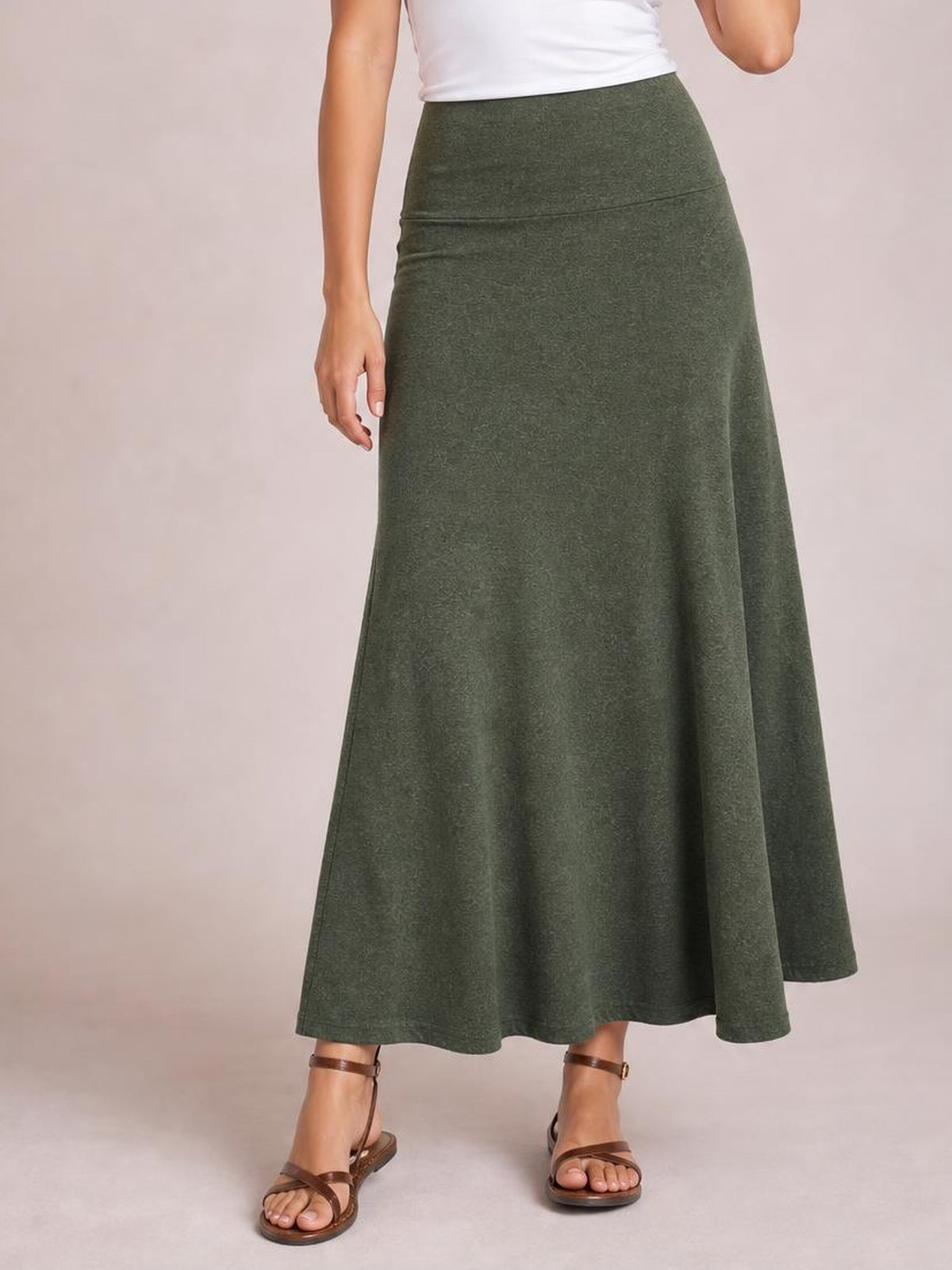 Model wears a solid olive-green elastic waist maxi skirt with a high-rise fit, smooth waistband, flowing A-line silhouette, and ankle-length hem.