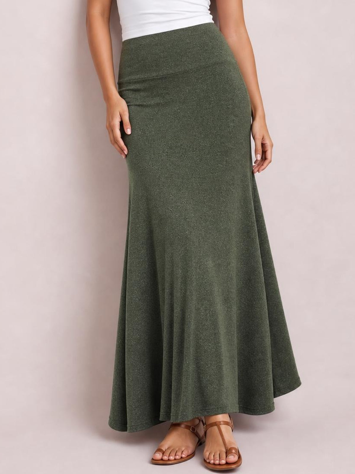 Model wearing a solid olive green elastic waist maxi skirt with a high-rise fit, smooth waistband, flowing A-line silhouette, and floor-length hem.
