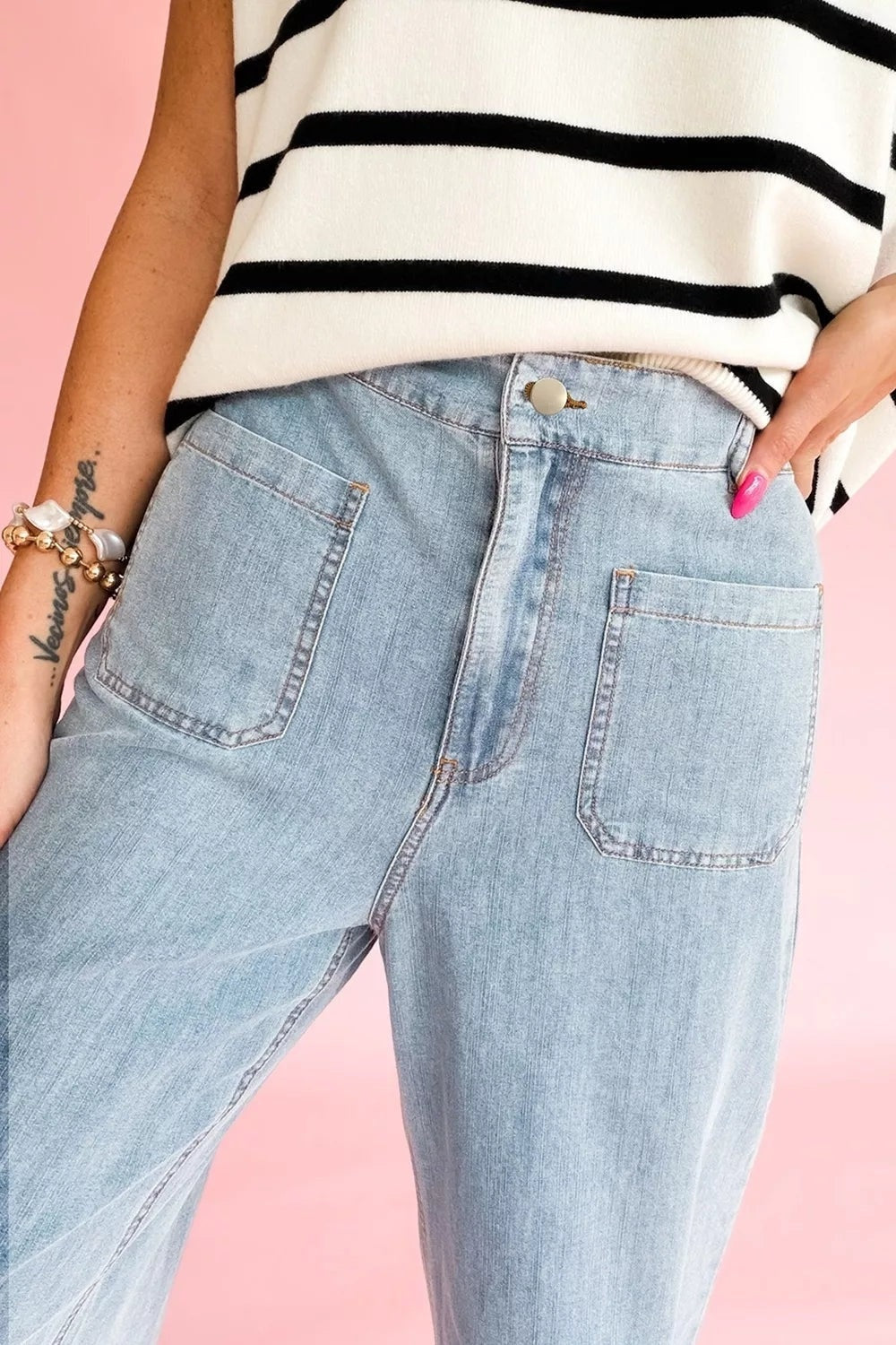 A model poses in light blue full-length jeans with a regular fit, button fly, belt loops, and large stitched front patch pockets.