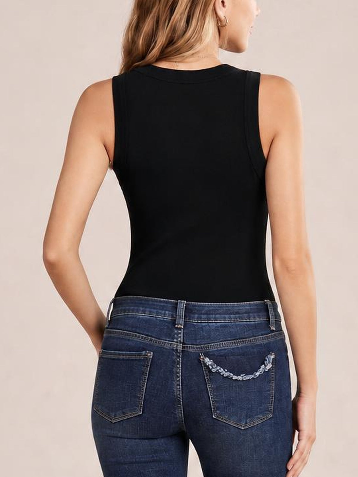 Model shown from the back wearing a solid black round neck tank with a sleeveless cut, smooth fitted silhouette, and neatly finished neckline and armholes.