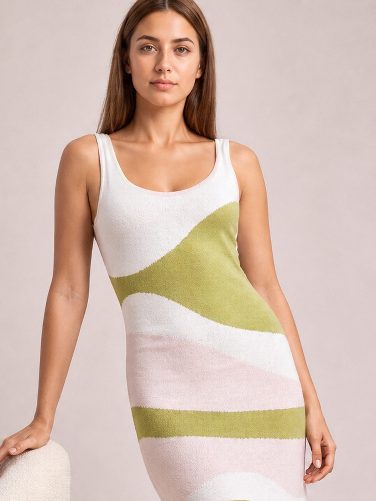 Model poses in a fitted spaghetti strap maxi sweater dress with a white, green, and blush pink abstract striped pattern and stretchy knit construction.