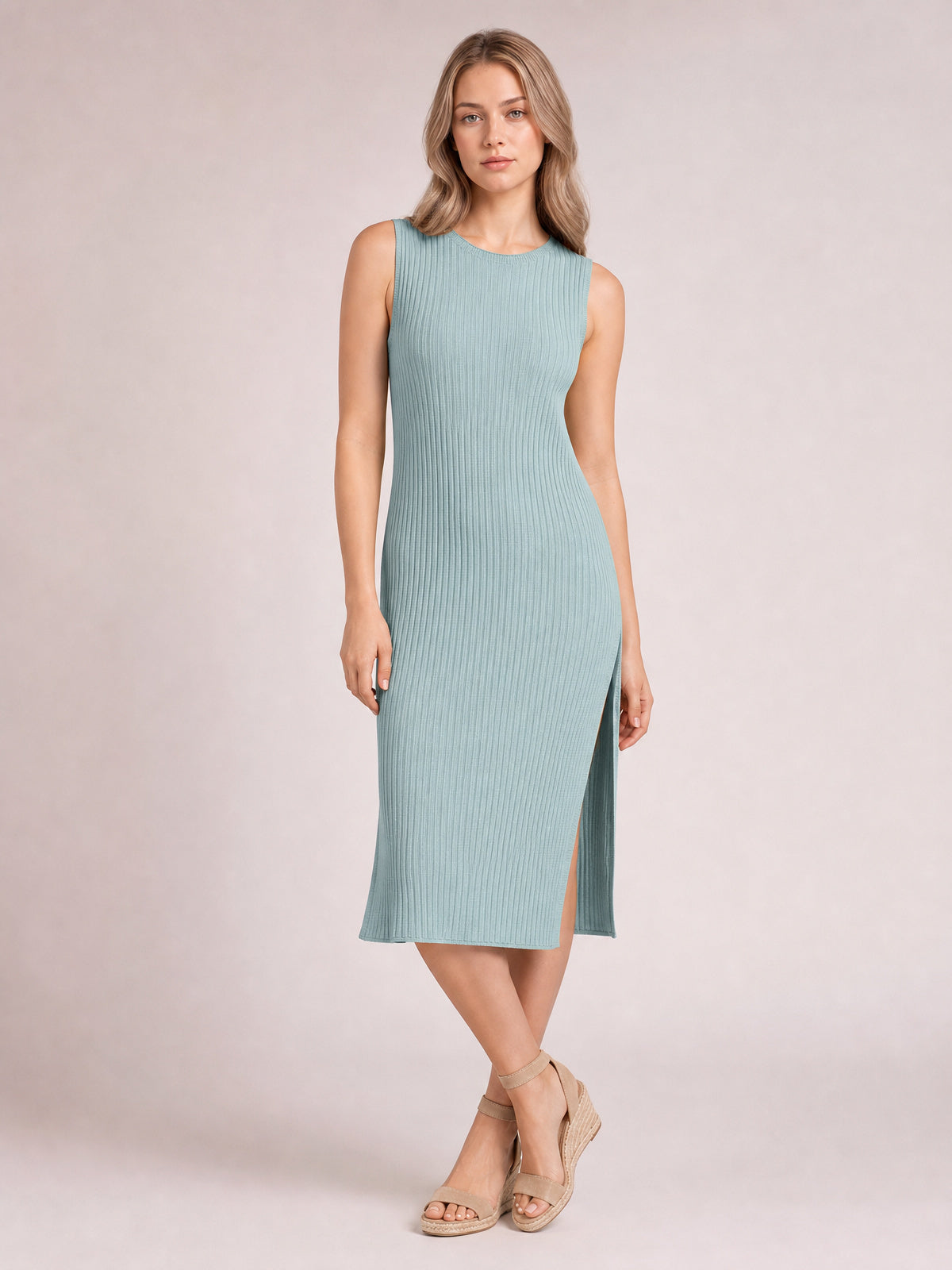 Model poses in a pale blue sleeveless midi dress with a round neck, vertical ribbed texture, body-skimming silhouette, and side split.