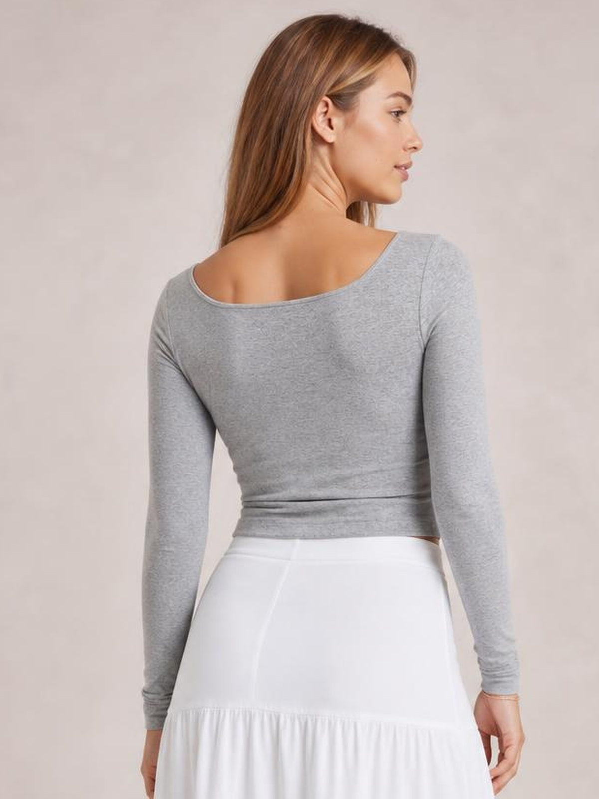 Model turned away in a gray square neck long sleeve T-shirt with a fitted silhouette, smooth construction, and slightly cropped hem.