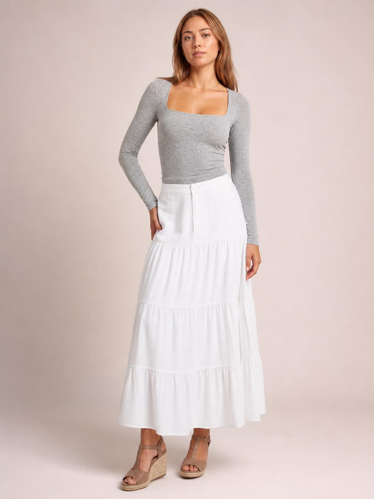 Model poses in a fitted gray square neck long sleeve T-shirt with a smooth, opaque finish and moderate stretch.