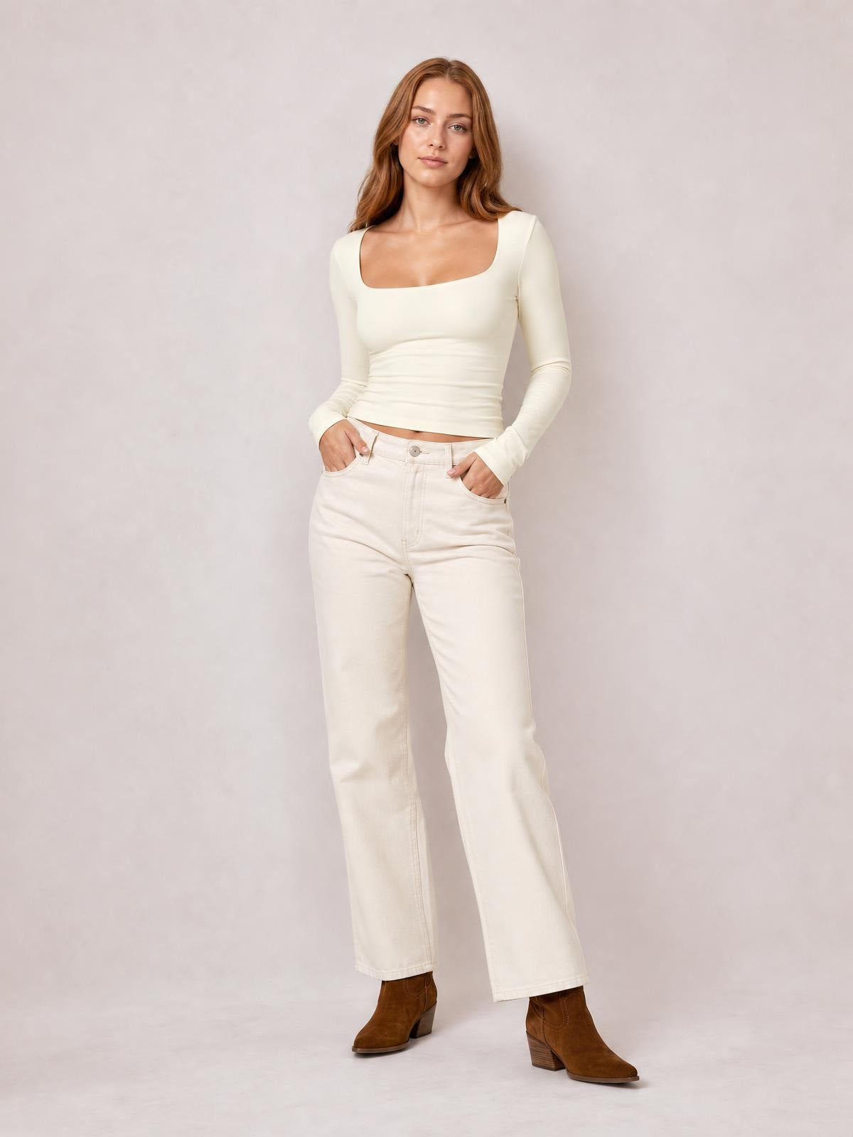 Model wearing an opaque ivory square neck long sleeve T-shirt with a fitted silhouette and moderate stretch, posing with hands in her pockets.