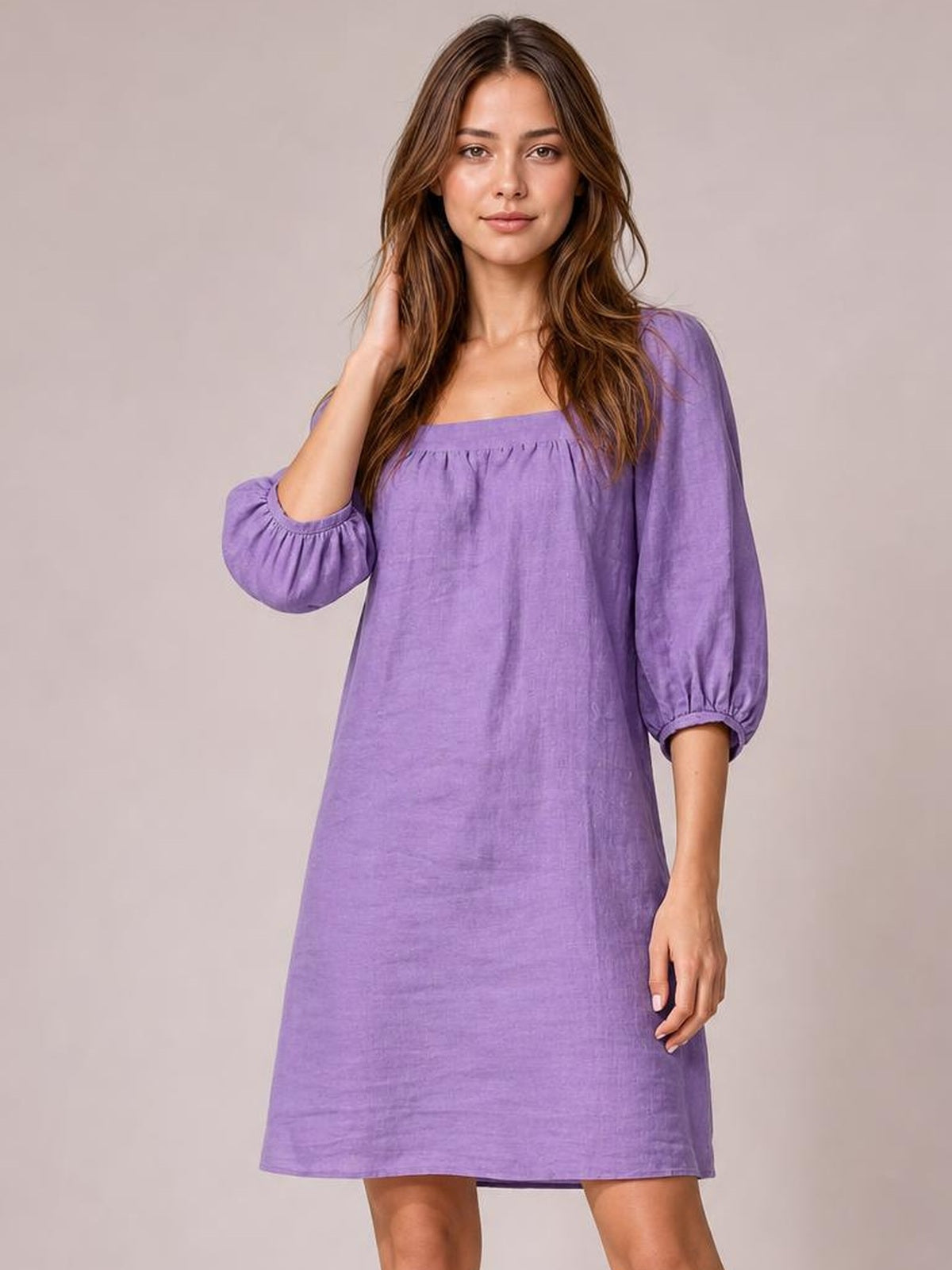 Model poses in a purple square-neck mini dress with relaxed A-line silhouette, gathered puff sleeves, and visible seam detailing.