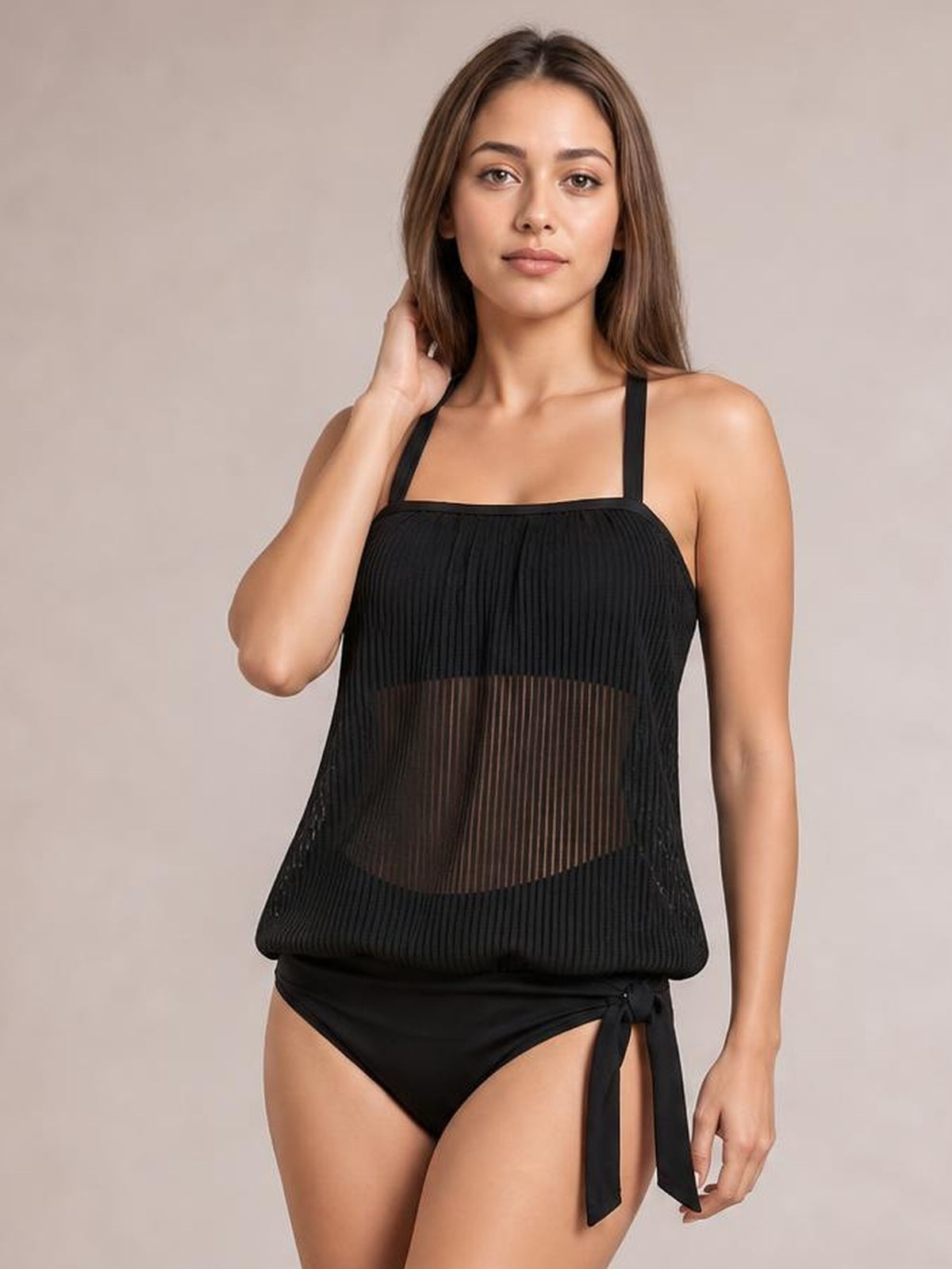 Model poses in a black square-neck spaghetti-strap tankini with a pleated sheer overlay, relaxed silhouette, and side-tie bikini bottoms.