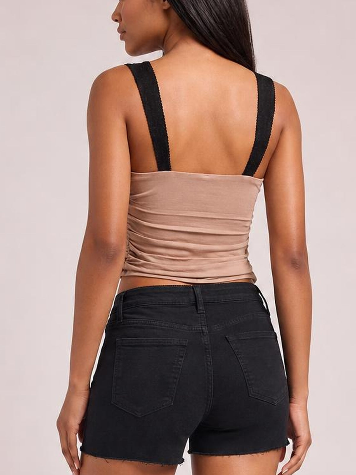 A model shown from the back wears a taupe wide-strap cami with a fitted silhouette, straight back neckline, and ruched construction through the waist.