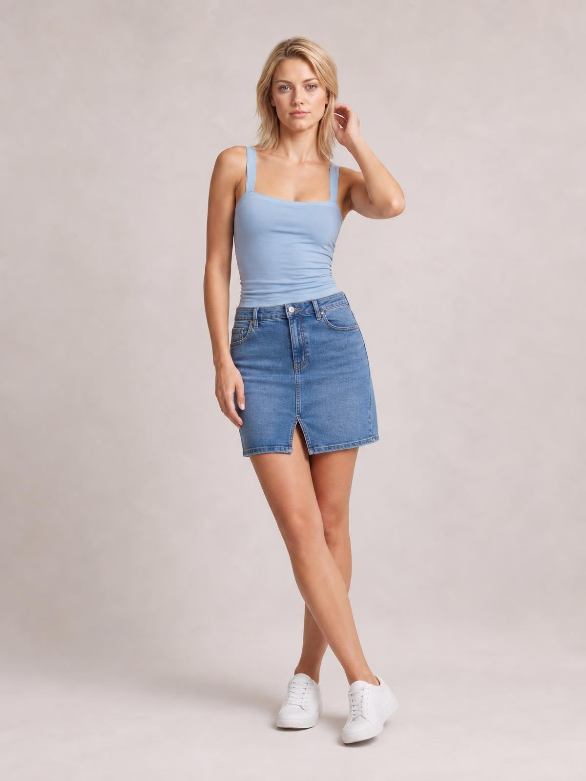 A model poses in a light blue square neck cami with wide straps and a close-fitting, slightly ruched silhouette.
