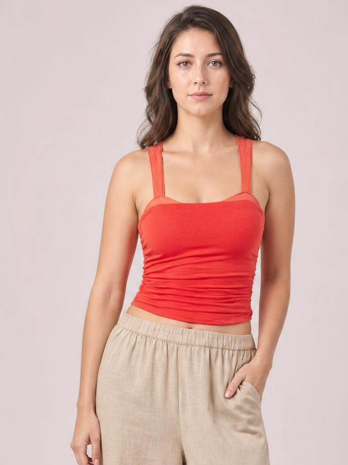 Model faces forward wearing a coral square-neck wide-strap cami with a fitted, slightly ruched silhouette and cropped hem.