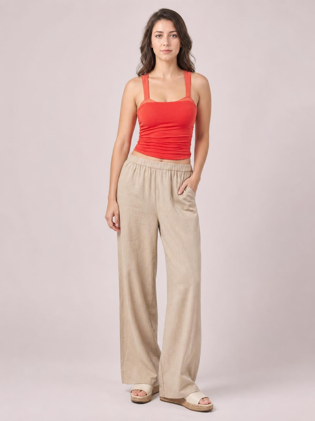 A model poses in a red square neck cami with wide straps and a close-fitting, slightly ruched silhouette.