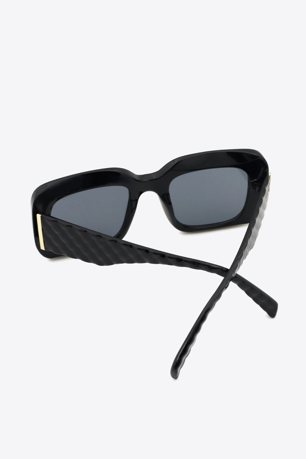 Black square polycarbonate UV400 sunglasses feature dark lenses, a bold structured frame, and thick sculpted temples crossed open to showcase the construction.