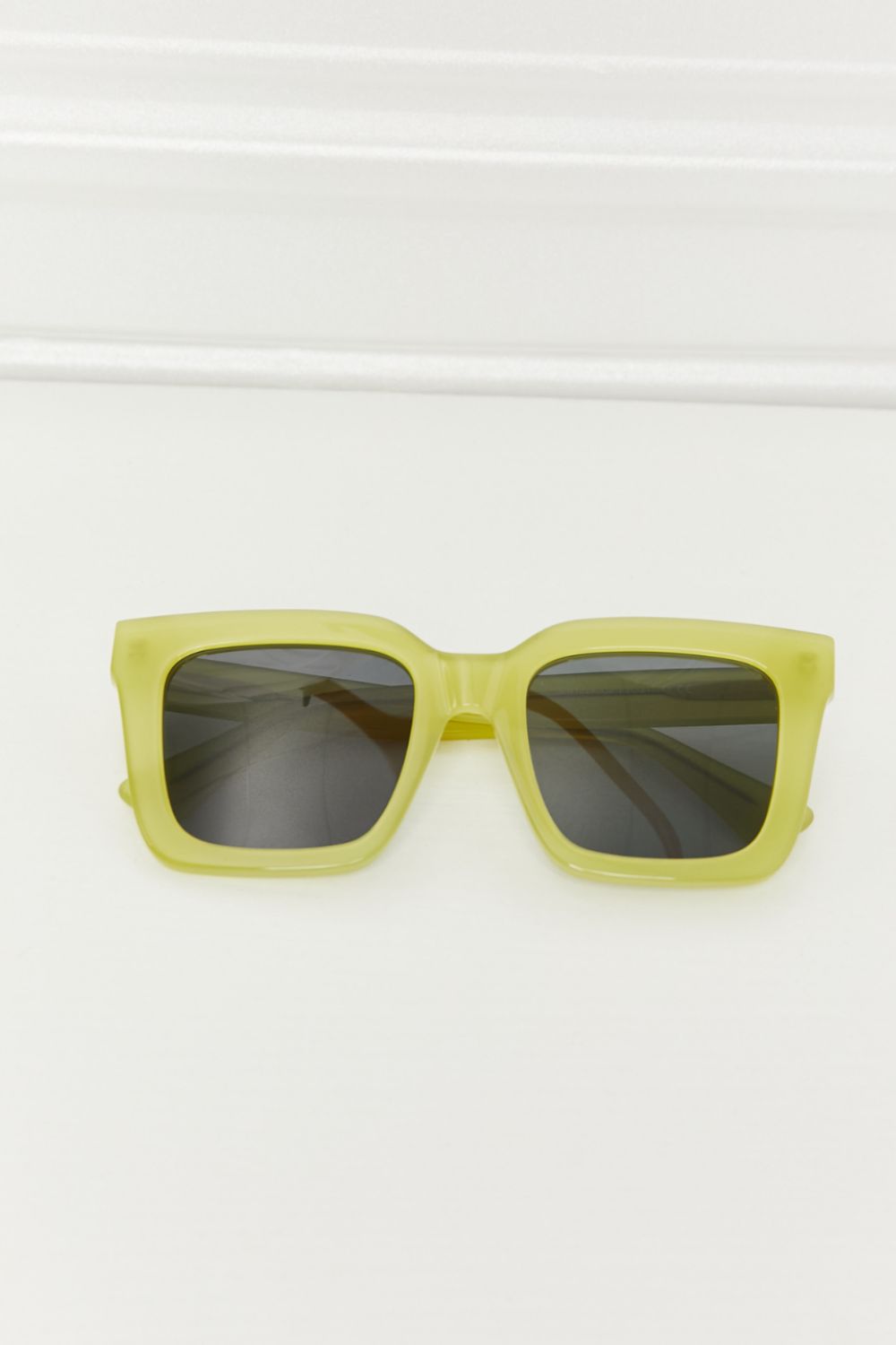 Square TAC polarized sunglasses feature a vivid neon yellow acetate frame, bold structured silhouette, thick temples, and dark lenses for striking contrast.