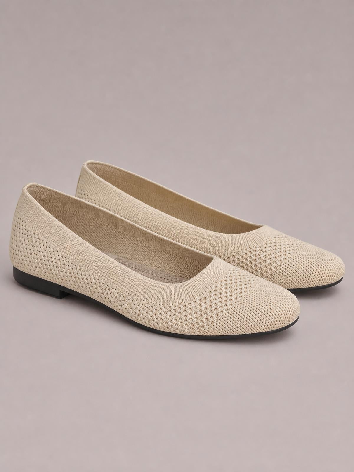 Beige solid-color mesh slip-on flats with square toes, low black rubber soles, rounded silhouettes, and seamless woven uppers.