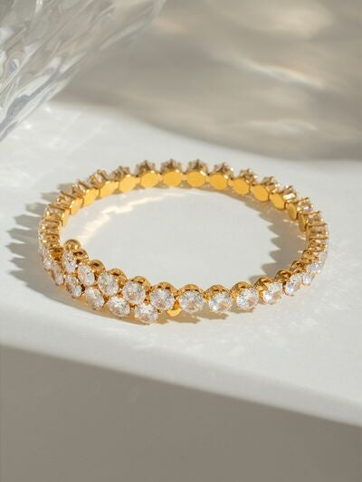 A gold-plated stainless steel bracelet features a slim circular silhouette with repeating round zircon stones set in sparkling gold-toned settings.