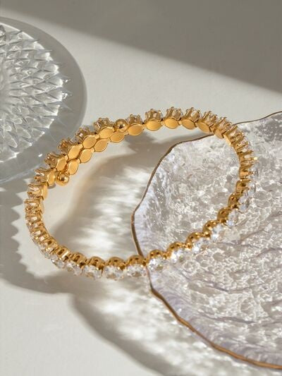 Gold-tone stainless steel inlaid zircon bracelet with a slim circular silhouette, faceted clear accents, and textured linked construction.
