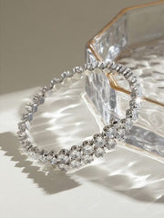 Silver-tone stainless steel bangle bracelet with inlaid clear zircon stones, a slim circular silhouette, and a sparkling clustered section at the front.