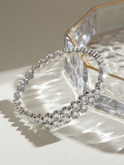 Silver-tone stainless steel bangle bracelet with inlaid clear zircon stones, a slim circular silhouette, and a sparkling clustered section at the front.