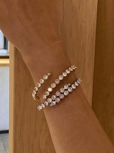 A model displays a gold-plated stainless steel inlaid zircon bracelet on the wrist, featuring rows of sparkling stones and a layered silhouette.
