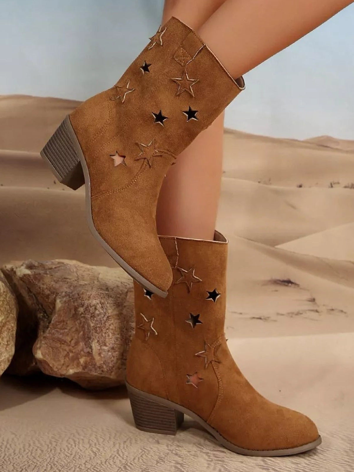 Model wearing tan suede block-heel boots with star-shaped cutouts, stitched details, rounded toes, mid heels, and rubber soles.