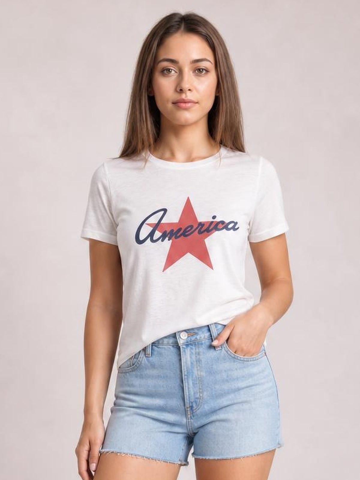 A model wears a white Star round neck short sleeve T-shirt with a red star and navy “America” graphic in a relaxed, easy silhouette.