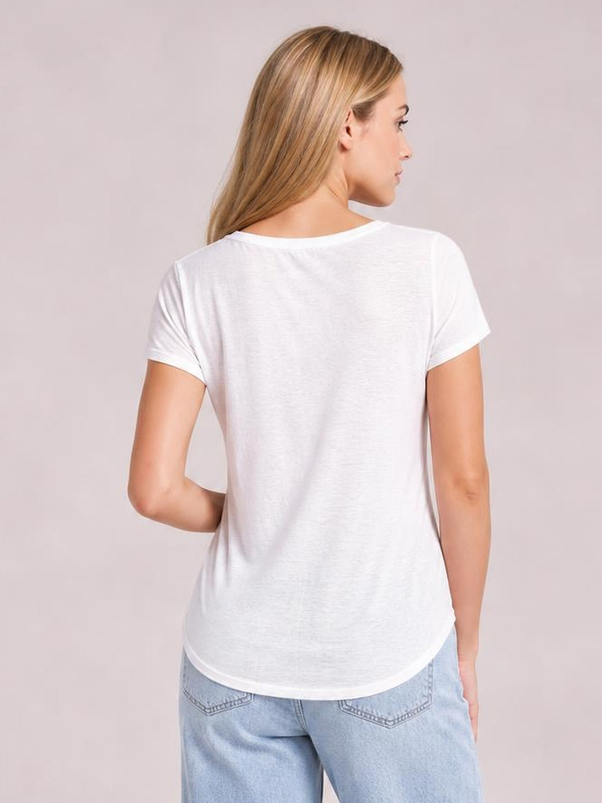 Model shown from the back in a white Star round neck short sleeve T-shirt with a relaxed silhouette, curved hem, and neat sleeve and neckline construction.