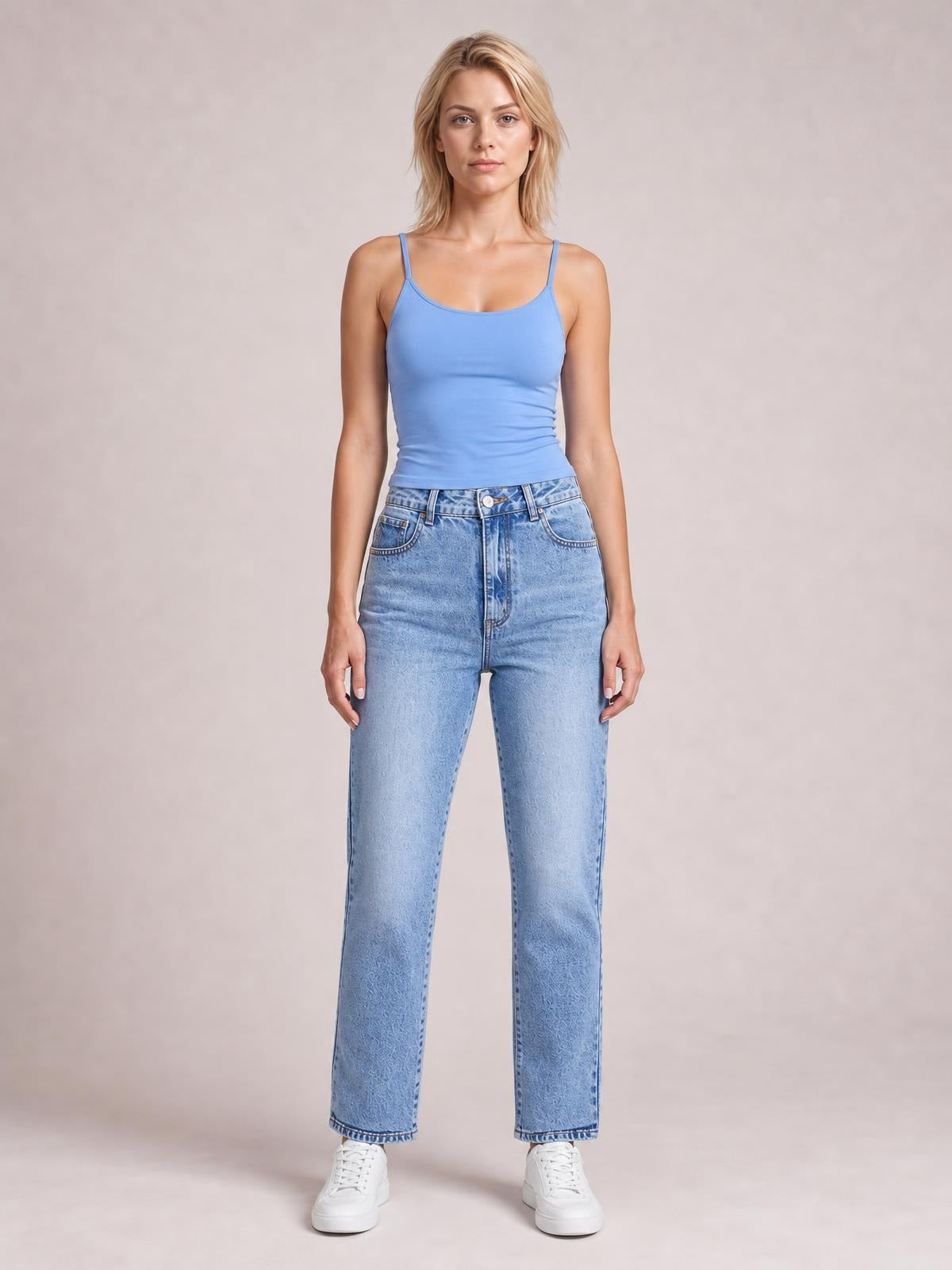Model stands facing forward in light blue straight-leg jeans with front pockets, belt loops, button closure, and a classic full-length silhouette.