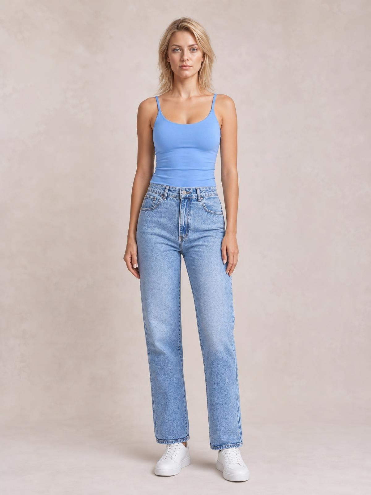 Model standing in light blue straight-leg jeans with front pockets, belt loops, button closure, and a relaxed silhouette.
