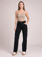 Model wearing black straight-leg cargo pants with a button fly, front pockets, and side utility pockets, posed with one hand in a pocket.