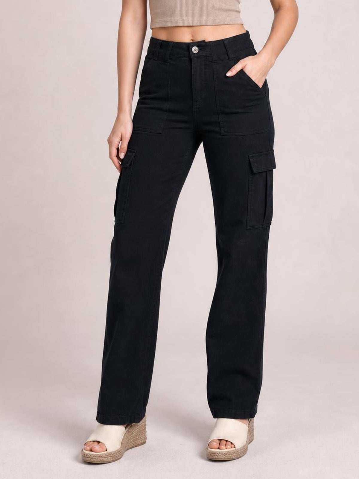 Model wearing black straight-leg cargo pants with a button fly, front pockets, and flap cargo pockets, posed with one hand in a pocket.