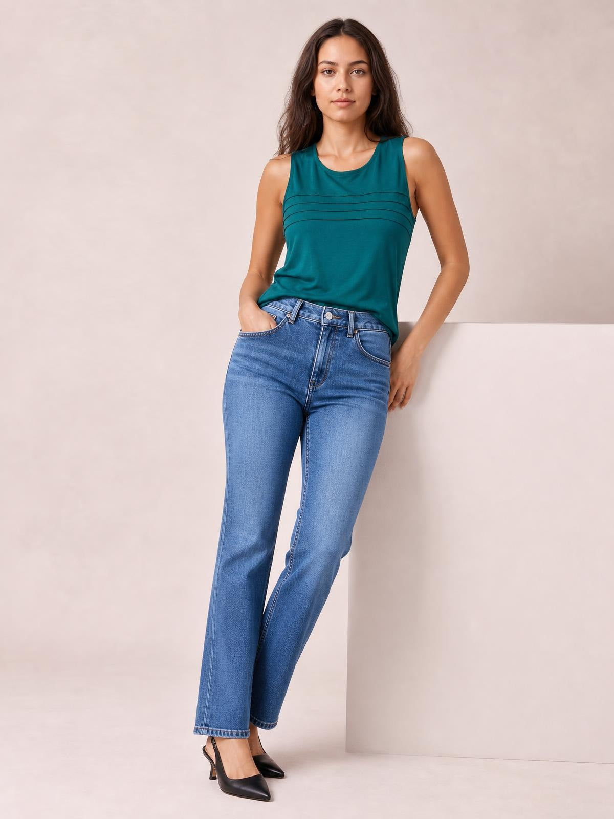 Model poses in light blue straight-leg jeans with front pockets, belt loops, button closure, zip fly, and a full-length silhouette.