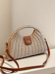 Medium straw woven crossbody bag with a rounded structured silhouette, adjustable brown strap, and leather-look flap with metal turn-lock closure.